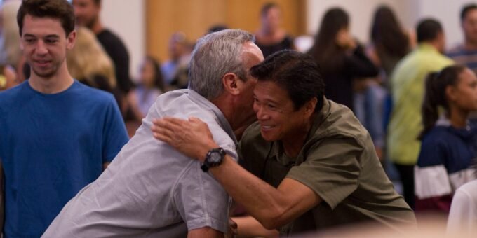 two men hugging on focus photography