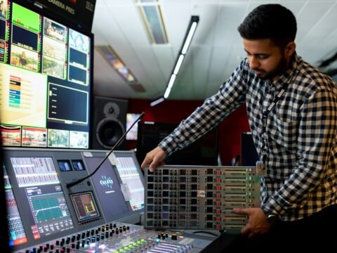 man in black and white checkered dress shirt playing dj controller