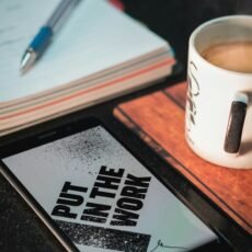 Honor smartphone beside mug and paper with pen